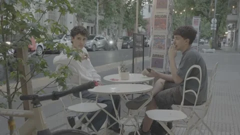 Two young men sitting at an outdoor café in Buenos Aires, Argentina Stock-Footage 345138002