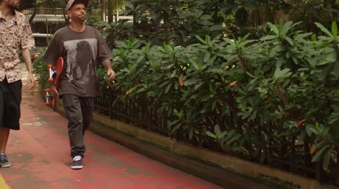 Two young men with skateboard walking on the footpath Stock Footage 61273719