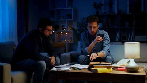 Two young men solve a problem while studying at home at night Stock-Footage 120390855