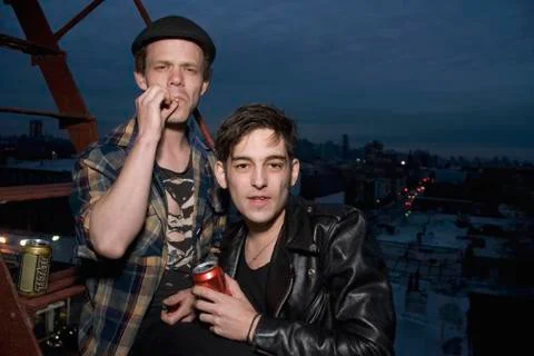 Two young men standing on a fire escape at night Stock Photos