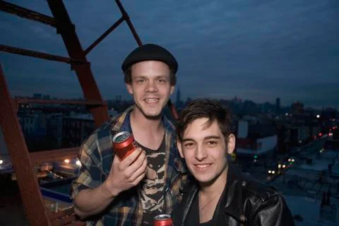 Two young men standing on a fire escape at night Stock Photos