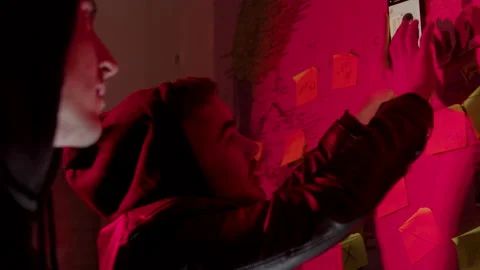 Two young men standing in front of wall map with strings Stock Footage 181824251