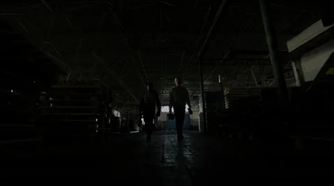 Two young men with the tools to the camera in a dark hangar Stock Footage 56198803