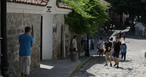 Two young men tourists walking into a museum in the old town of Plovdiv Video stock 93892576