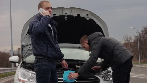 Two young men trying to repair the car Stock Footage 70398931