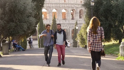 Two young men walk in park road get distracted and turn to look at beautiful Stock Footage 85234271