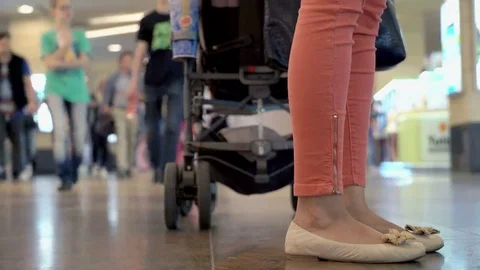 Two young moms with three babies shopping in the Mall with strollers and toys Stock Footage 69189775