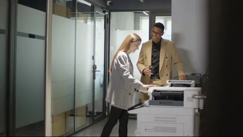 Two young multiethnic colleagues is copying documents at office standing near Stock Footage 225685138