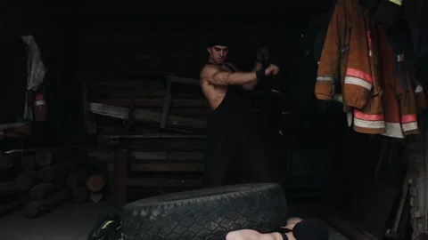 Two young muscular men train and do extreme crossfit exercises with a tire and a Stock-Footage 130177892
