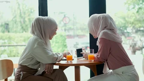 Two young muslim women sitting to discussing in coffee shop Stock Footage 147903853