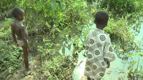 TWO YOUNG PAKRO BOYS STAND BY RIVER Stock Footage 58930501