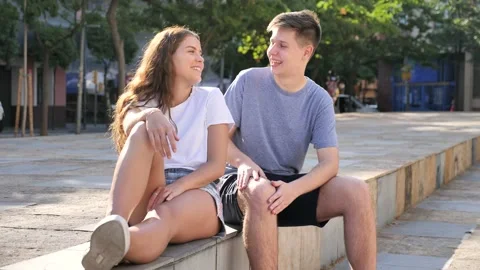 Two young people are having a conversation while sitting on the step Video stock 218342709