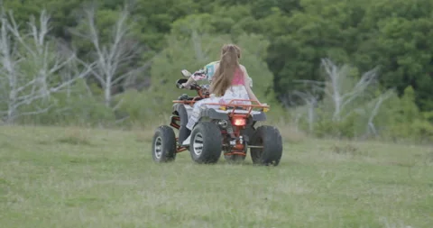 Two young people are having a good time riding ATVs. Two tourists roam the Stock Footage 221493826