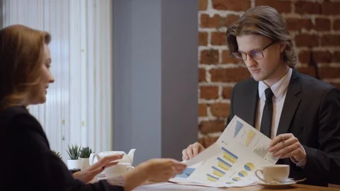 Two young people are working together and discussing projects in a cafe. The Stock Footage 102953835