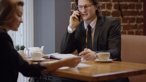 Two young people are working together and discussing projects in a cafe. The Stock Footage 102953879