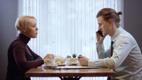 Two young people are working together in a cafe. They have business lunch. The Stock Footage 103137956