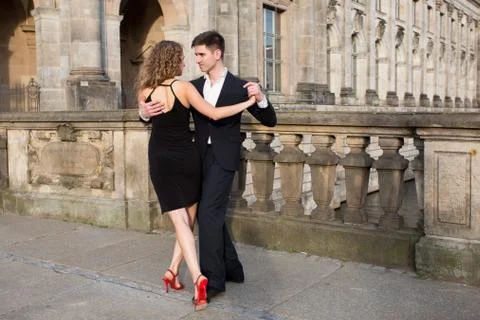 Two young people dancing tango outside on the old stone bridge Stock Photos