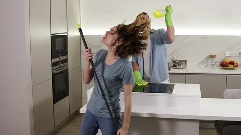 Two young people dancing together and emotionally singing using broom and 스톡 동영상 123938195