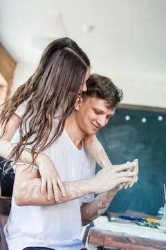 Two young people having fun in a pottery workshop. Couple Wearing White T-Shi Stock Photos