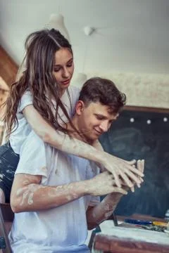 Two young people having fun in a pottery workshop. Couple Wearing White T-Shi Stock Photos