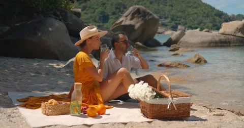 Two young people having rest on secluded sunny beach, having picnic, rest and Stock Footage 163155550