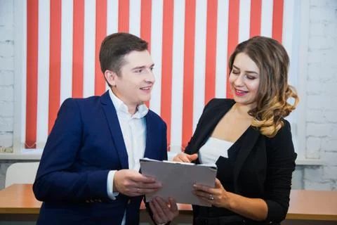 Two young people hold documents discuss business freelance project 写真素材