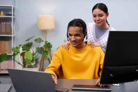 Two young people reviewing code together using compiter Fotos Stock