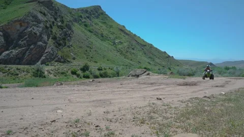 Two young people riding a quad bike in mountains Video stock 186971849