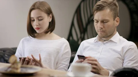 Two young people is sitting in a cafe. Man and woman are smiling and sitting in Stock Footage 94473790