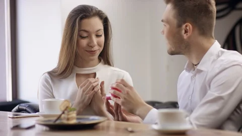 Two young people is sitting in a cafe. Man and woman are smiling and sitting in Stock Footage 94669125