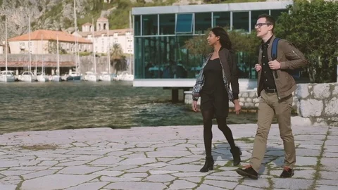 Two young people walk down beach, looking at nature Stock Footage 75921215