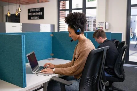 Two young people work side by side in office with desk dividers, coworking Stock Photos