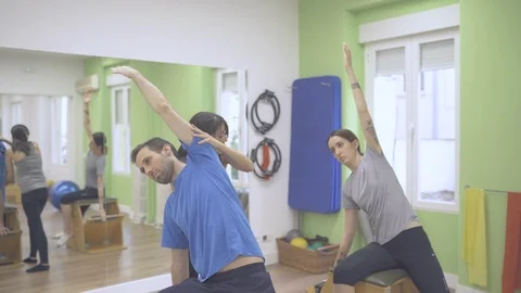 Two young pilates students exercising their upper body with a wunda chair Stock Footage 126976738
