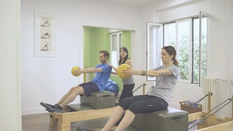 Two young pilates students working their upper body with a wunda chair Stock Footage 126977079