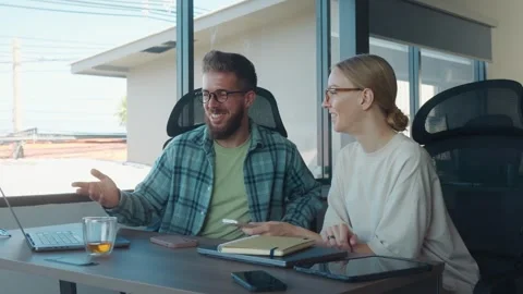 Two young professionals are collaborating on project, pointing at laptop screen Stock Footage 312114574