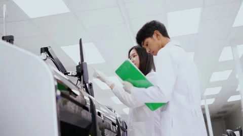 Two young scientist looking at results from automation blood analyzer reported Stock Footage 134273674
