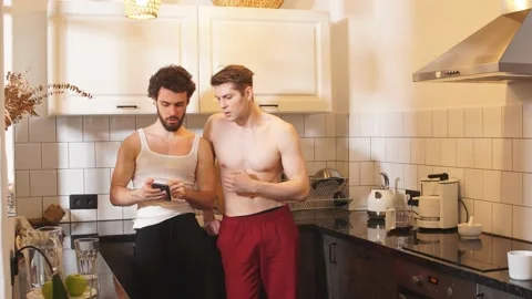 Two young sexy guys in the kitchen. Love and relationships. Stock Footage 127020655