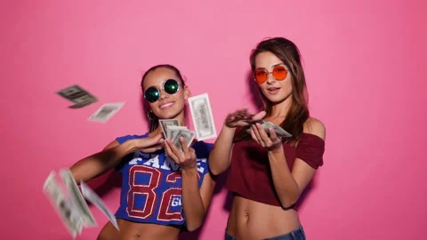 Two young sexy stylish smiling brunette women making it rain money Stock Footage 140674342