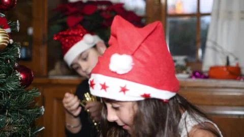 Two young sisters at home decorating Christmas Tree Stock Photos