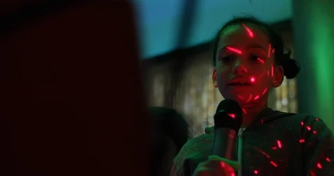 Two young sisters singing together at a karaoke event Stock Footage 104046707