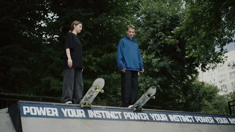 Two young skaters talking and gesturing on a concrete ramp in an urban outdoor Video stock 340538640