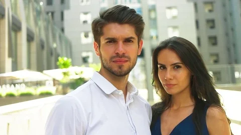 Two young smiling colleagues staying near modern business center and posing on Stock Footage 73813282