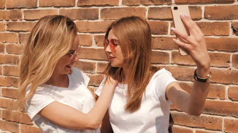 Two young smiling hipster blond women in summer white t-shirt Stock-Footage 141240847