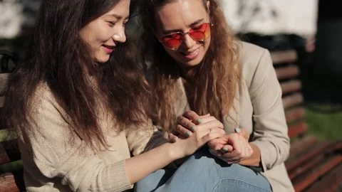 Two young smiling hipster women in summer clothes. Female showing positive face Stock Footage 233677853