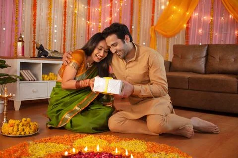 Two young smiling Indian exchanging gifts / surprises: Diwali Festival Stock Photos