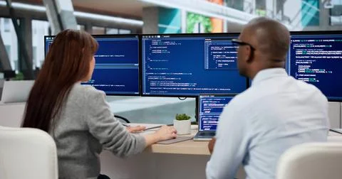 Two Young Software Developers Coding Together At Their Office Desk. Focused E Stock Photos