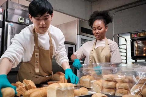 Two young startup partners taking orders of pastry and bakery food shop. Stock Photos