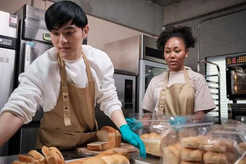 Two young startup partners taking orders of pastry and bakery food shop. Stock Photos