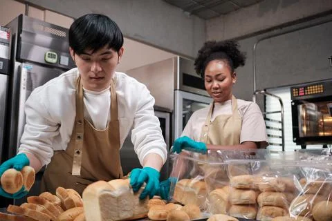 Two young startup partners taking orders of pastry and bakery food shop. Foto stock