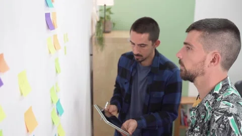 Two young startup workers planning concept. Front of wall marker and stickers. Stock Footage 140516751